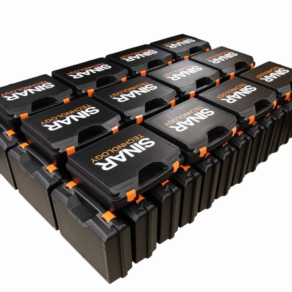 Printed-Plastic-Carrying-Cases - PottertonPacs Row of black printed protective cases with orange latches, stacked in a neat grid, labeled TECHNOLOGY on each case